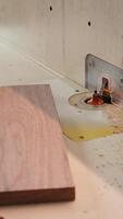 Vertical Carpenter in studio puts wood block through spindle moulder, creating smooth edges on wooden pieces. Cabinetmaker in joinery using heavy machinery to craft joints for furniture, camera B close up video