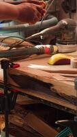 Vertical African american manufacturer shaping raw timber using chisel and hammer, creating wood art, making precise cuts. Artist making handmade wood sculptures, engraving lumber with tools, camera A close up video