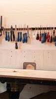 Vertical Chisels, screwdrivers, wrench and pliers on wall in furniture assembly shop used for carving wood surfaces. Close up of woodworking gear on rack in carpentry studio, panning shot video