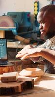 Vertical Carpenter looking over blueprints schematics on laptop in CAD software with apprentice. Woodworkers designing custom 3D furniture on notebook in studio, preparing for client order, camera A video