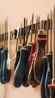 Vertical Chisels, screwdrivers, wrench and pliers on wall in furniture assembly shop, panning shot. Close up of various woodworking tools on rack in joinery used for working with wood materials video