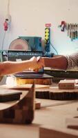 verticale ébéniste tremblement collègue main après finition en utilisant cad Logiciel sur portable à conception en bois objets. charpentiers féliciter chaque autre pour emploi bien terminé dans meubles assemblage boutique, caméra b video