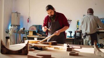 Schreiner bewirbt sich Lack auf hölzern Oberfläche zu verhindern Beschädigung und zur Verfügung stellen Schicht von Schutz. Holzbearbeitung Experte im Studio tun Fertigstellung auf Holz Planke, Putten Mäntel von Öl, Kamera b video