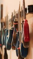 Vertical Chisels, screwdrivers, wrench and pliers on wall in carpentry studio, panning shot. Close up of various woodworking tools on rack in workshop used for repairing or creating wooden objects video