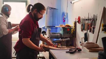 Holzarbeiter mit Bank Schraubstock zu halt Holz Block, beginnend Möbel Montage im Werkstatt. Handwerker im Tischlerei mit Laster Werkzeug zu Klemme Stück von Holz Vor Carving Es, Kamera b video