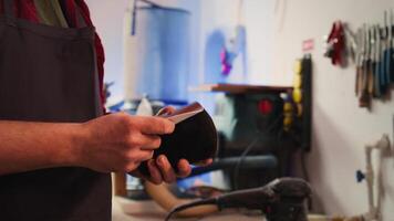 Carpenter putting sandpaper on piece of plastic, creating abrasive sponge to smooth surfaces. Man preparing necessary gear for furniture assembling job in studio, close up shot, camera B video