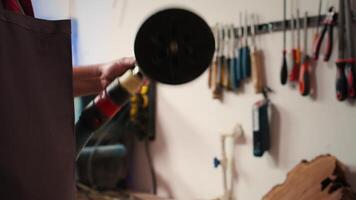 artisan en mettant papier de verre disques sur ponceuse dispositif à être utilisé sur lissage bois surfaces. travail du bois expert en train de préparer nécessaire équipement pour meubles assemblage commission, proche en haut, caméra b video