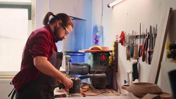 Zimmermann zusammenarbeiten mit Lehrling, mit Orbital Schleifer mit fein Sandpapier zu leisten raffiniert beenden. Hersteller und bipoc Kollege mit Winkel Schleifer auf Holz Block, Kamera b video