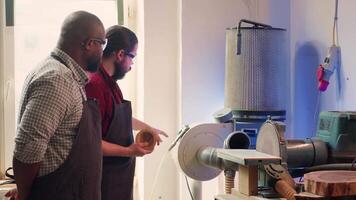 fabrikant onderwijs nieuw werknemer hoe naar vorm houten kom Aan schijf schuurmachine in in elkaar zetten winkel. leerling aan het leren van houtbewerking specialist hoe naar gebruik slijpen machine roterend schijf, camera een video