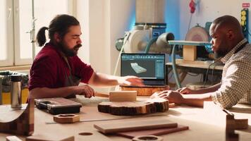 hantverkare och lärling jämförande trä konst bit med schematisk visas på cad programvara på bärbar dator. träbearbetning experter i studio korskontroll trä- objekt med anteckningsbok plan, kamera en video
