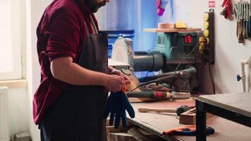 timmerman in houtbewerking winkel zetten Aan bescherming handschoenen voordat in elkaar zetten meubilair. meubelmaker vervelend veiligheid uitrusting voordat beginnend werk naar vermijden verwondingen, camera een video