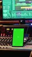 Vertical Team of producer and artist use tablet with mockup display in professional studio, mixing and mastering tracks after recording session. Experts working in control room with console. Camera A. video