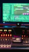 verticaal leeg geluiddicht controle kamer in professioneel opname studio, stereo uitrusting met schuifregelaars en faders Aan paneel bord. professioneel post productie ruimte met audio opname software. video