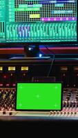 verticaal audio technicus werken met muziek- opname software en bewerken deuntjes, menging troosten en controle paneel bord in post productie studio. producent in werking technisch apparatuur. camera a. video