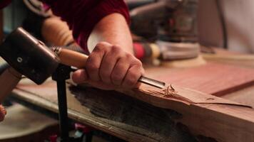 artisan sculpture dans bois en utilisant ciseau et marteau dans charpenterie magasin avec précision. fabricant dans studio façonner en bois pièces avec outils, fabrication bois art, caméra une proche en haut coup video
