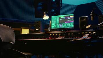 African american audio engineer uses compressor and mixer in professional studio, changing volume level and sound settings on a recording. Music production in control room. Camera B. video