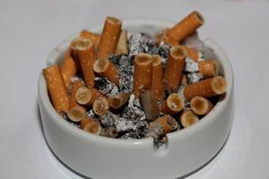 lleno cenicero de cigarrillos cerca arriba macro ver de fumar hábitos alta resolución valores fotografía y imágenes alto calidad grande Talla instante descargar foto