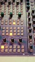 vertical pre amperio perillas y conmutadores en mezcla consola panel junta, audio estéreo equipo usado en música enviar producción. vacío controlar habitación en profesional estudio, fader y deslizadores cerca arriba. video