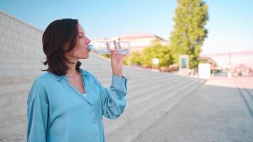 une femme en buvant l'eau de une bouteille video