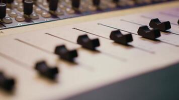 Pre amp knobs and switchers on mixing console panel board, audio stereo equipment used in music post production. Empty control room in professional studio, fader and sliders. Close up. video