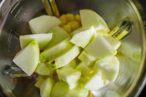 Green apple in Blender for smoothie preparation photo