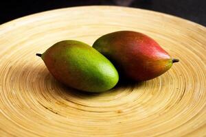 Mango on beatiful wooden tray laying side by side photo