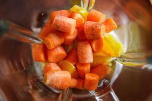 Carrot in blender being prepared for smoothie making photo