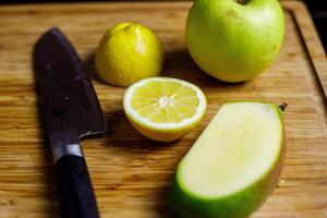 Lemon, Mango and green apple on wooden cutting board for smoothie preparation photo