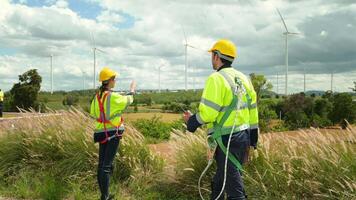 inteligente ingenieros con protector casco sacudida manos a eléctrico turbinas campo video