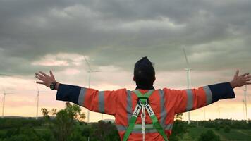 Smart engineer with protective helmet rising hands up at electrical turbines field video