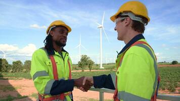 Smart engineers with protective helmet shaking hands at electrical turbines field video