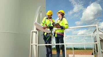 intelligent ingénieur avec protecteur casque en portant le plan travail à électrique turbines champ video