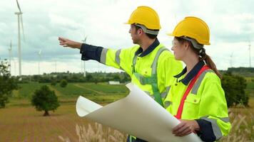 slim ingenieur met beschermend helm Holding de blauwdruk werken Bij elektrisch turbines veld- video