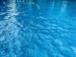 Background dynamic splash of clear water creating swirling wave in blue water with droplets suspended in motion. Clean water concept. photo