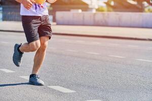 atlético hombre trotar en ropa de deporte en ciudad la carretera foto