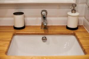 Faucet in sink with wooden countertop photo