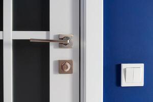 White interior door with handle. Blue wall in modern apartment photo