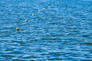 Floating buoys barrier on sea water photo