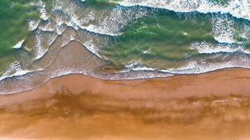 Ocean waves on the beach as a background. Aerial top down view of beach and sea with blue water waves. Vietnam beach video