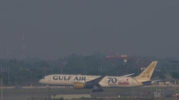 BANGKOK, THAILAND - MARCH 01, 2023. Passenger aircraft Boeing 787-9 Dreamliner, A9C-FE of Gulf Air acceleration and takeoff at Suvarnabhumi Airport, side view. Travel concept video