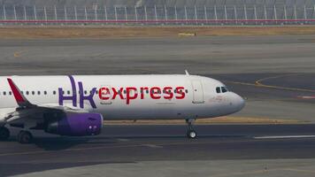 HONG KONG - NOVEMBER 10, 2019. Passenger plane Airbus A321, B-LEH of HK express taxiing at Chek Lap Kok Airport, side view. Airplane on the taxiway or on the runway video