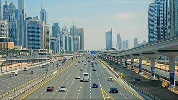 UAE, Dubai - United Arab Emirates 01 April 2024 Dynamic Dubai Highway and Metro, Traffic flows on a Dubai highway with the city's metro line overhead and skyscrapers lining the horizon. video
