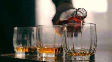 Whiskey Pouring Into Glasses, Close-up of amber whiskey being poured into glasses, with a warm glow. video