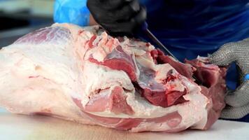 Butcher Trimming Pork Meat with Knife, Close-up of a butcher's hands expertly trimming fat from raw pork. video