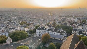 França Paris 05.04.2024 pôr do sol sobre parisiense telhados, a caloroso brilho do pôr do sol banha a telhados do Paris, com a eiffel torre dentro a distância. video