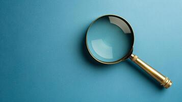 A single antique magnifying glass, placed against a muted colored background, symbolizes curiosity and discovery photo