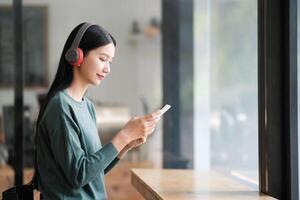 A woman is sitting at a table with a cell phone in her hand photo