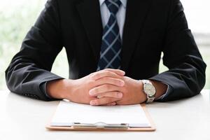 Close-up of a businessman's hands over a contract, ready for a formal agreement. photo