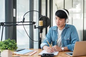 un hombre vistiendo auriculares es escritura en un pedazo de papel foto