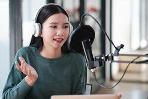 A woman wearing headphones and a microphone is recording a voice photo